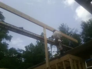 Carpenter setting a ridge beam over a new addition frame — Ice Dam Removal by Roofing Brothers in Decaturville