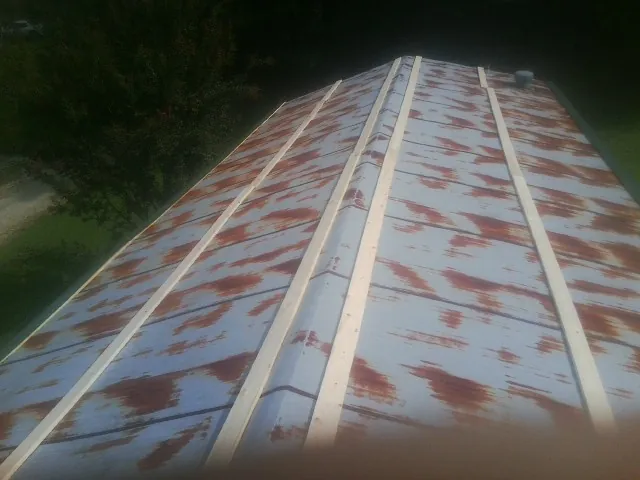 Rusted metal roof panels with new wood purlins before replacement — Storm Damage Roof Repair in Decaturville by Roofing Brothers