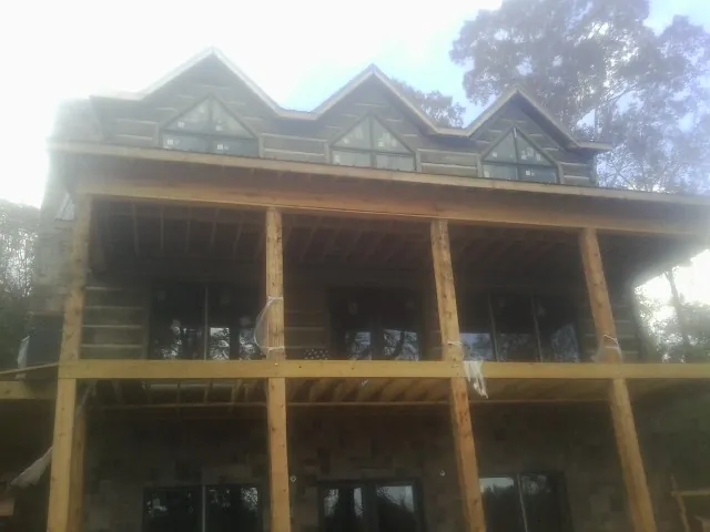 Dormers and porch framing on a large log home under construction — Roof Coating work by our crew in Decaturville