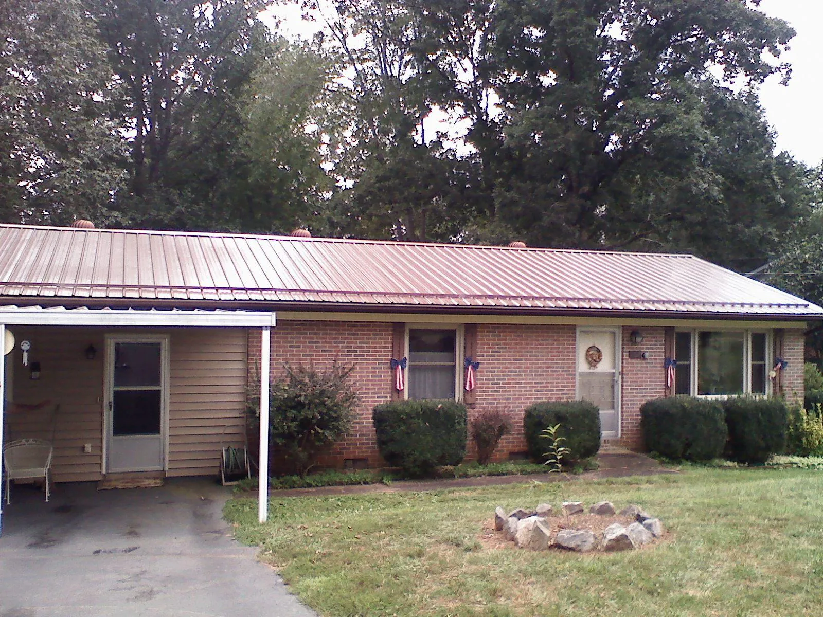Bronze metal roof and carport on a brick ranch home — Roof Repair work by our crew in Decaturville