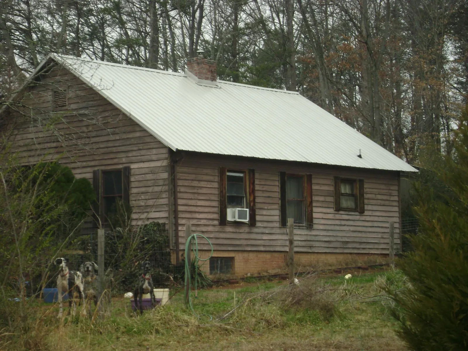 White metal roof on an old wood sided farmhouse, from a Metal Roof Installation job in Decaturville
